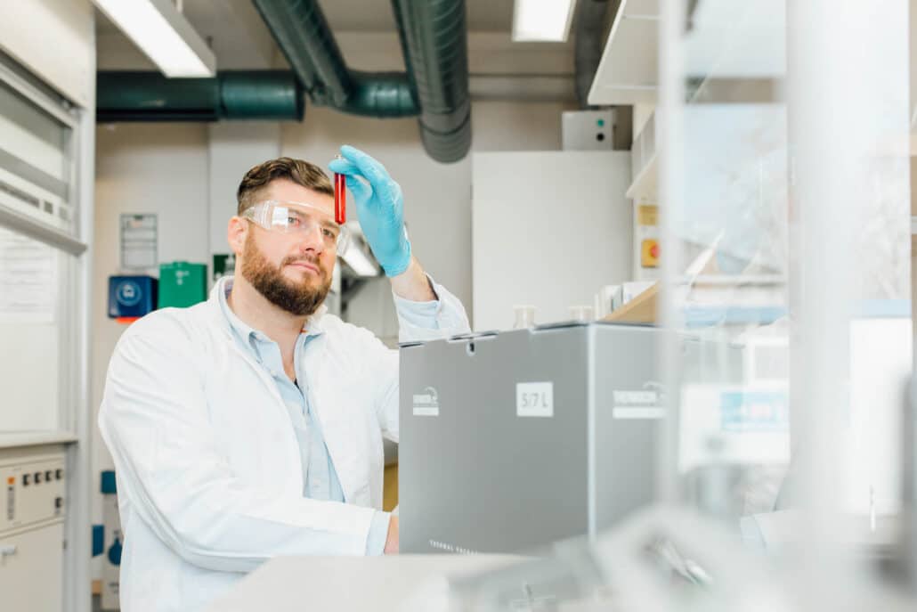 Laboratory technician handling a coolant pack above a THERMOCON Slim Line shipper