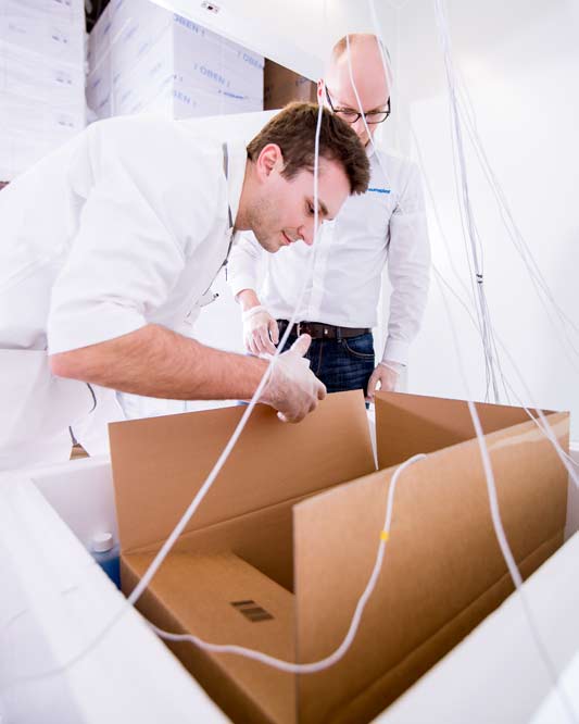 Technicians positioning sensor leads in a thermal packaging test setup