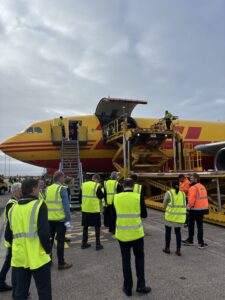 Partecipanti a FlyPharma Copenhagen 2026 davanti a un aereo cargo DHL all’aeroporto di Copenaghen